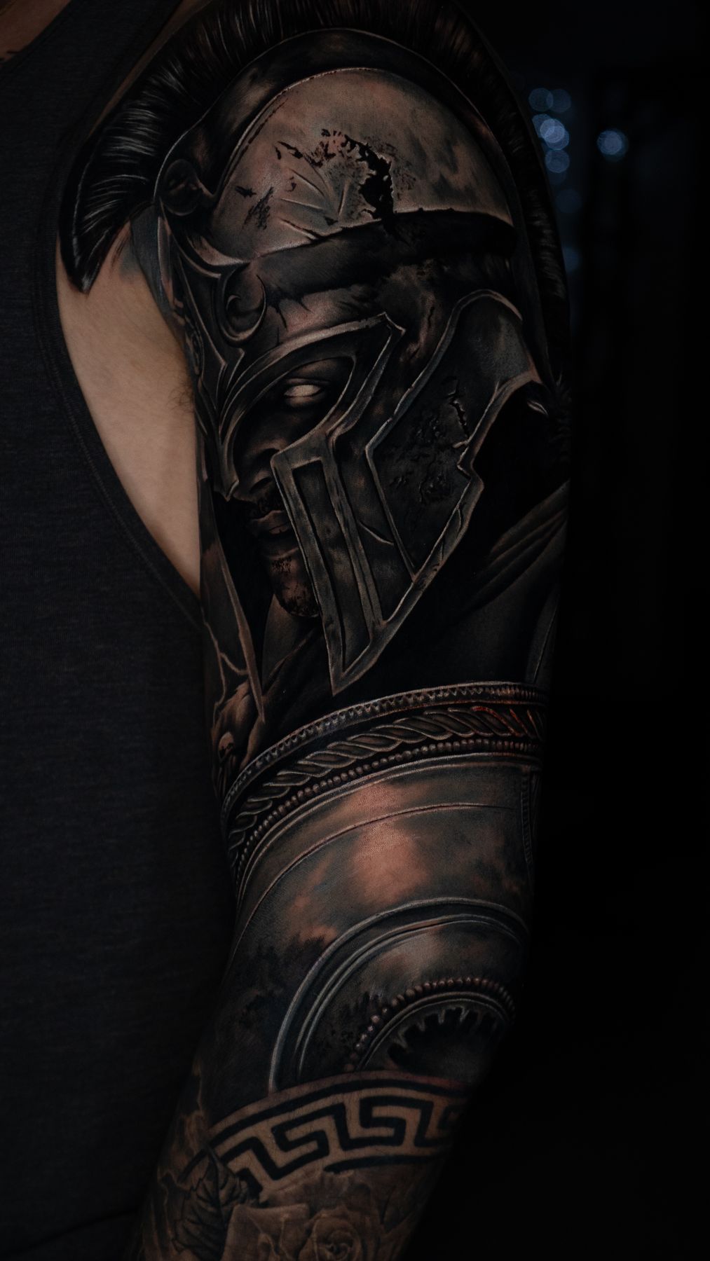 Tatuaje en brazo de casco y armadura espartana, estilo realismo Black and Grey